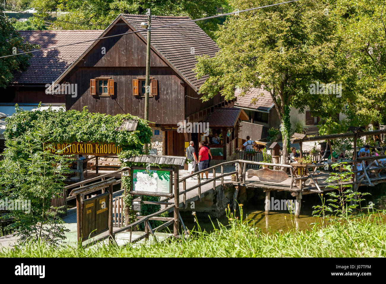 Touristen in einem Restaurant am Slunjcica Fluss in Rastoke Dorf, Kroatien Stockfoto