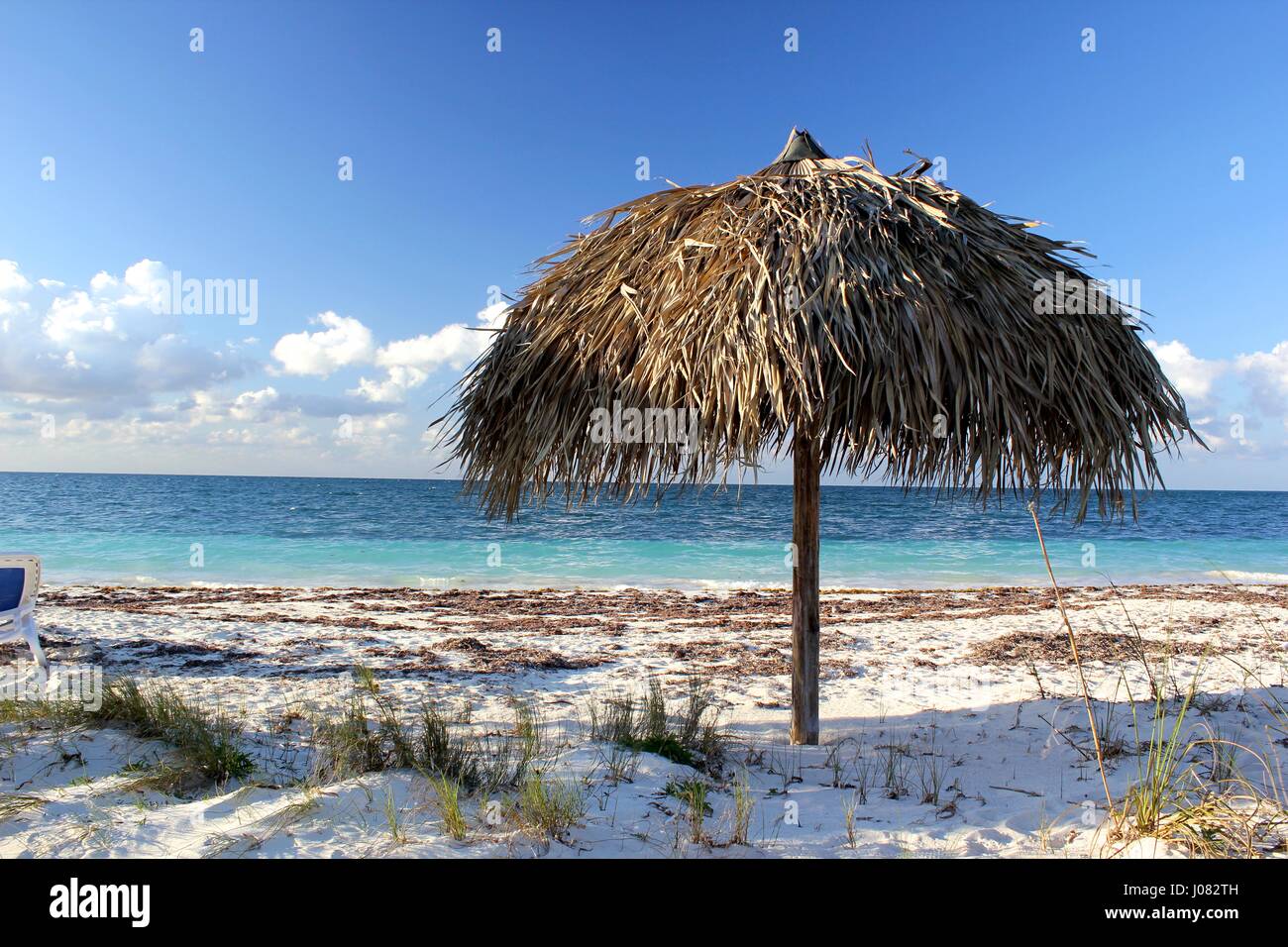 Ein Dach aus Palmblättern am Strand von Cayo Levisa gemacht wie die Sonne beginnt zu setzen Stockfoto