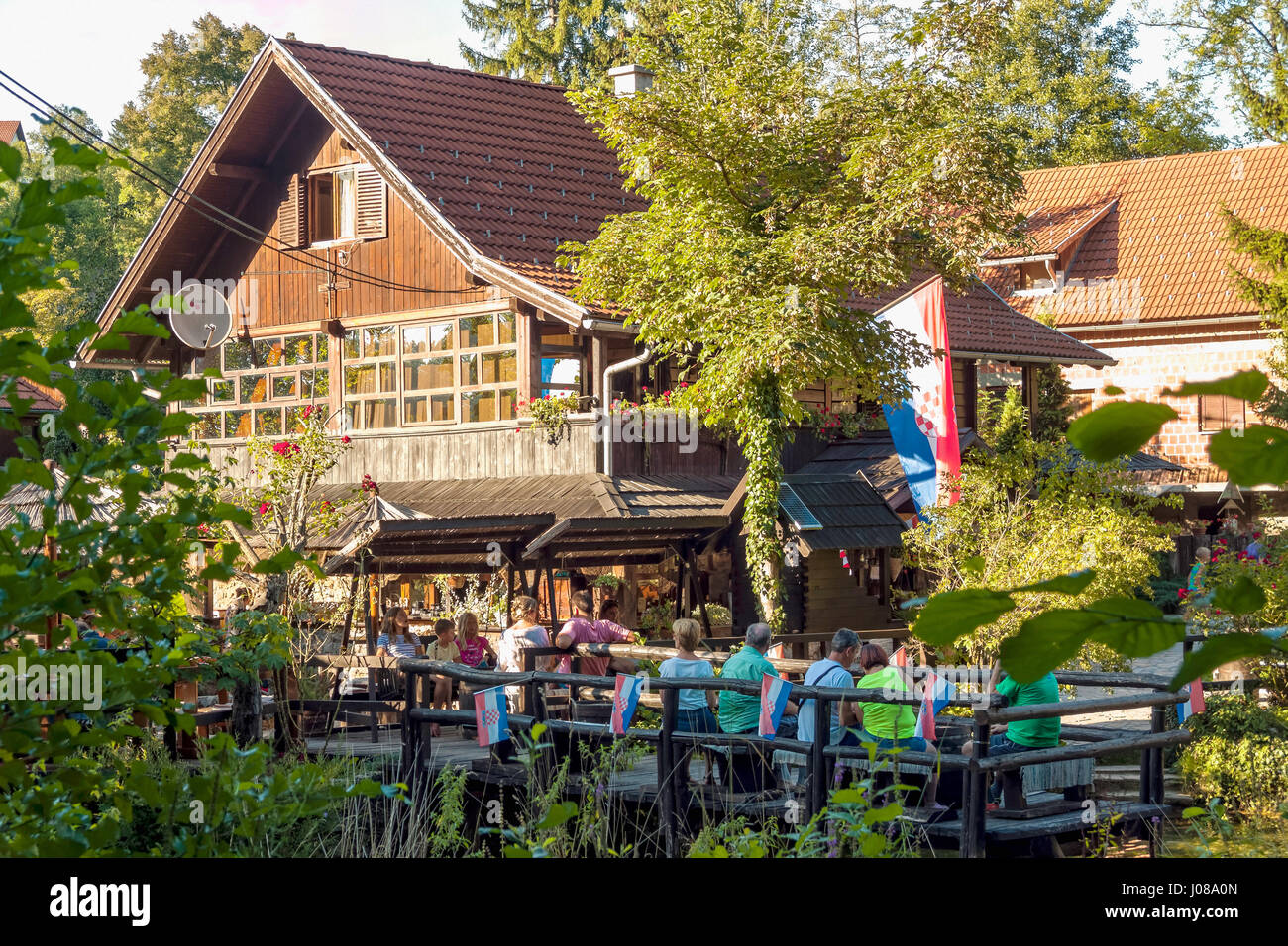 Touristen in einem Restaurant am Slunjcica Fluss in Rastoke Dorf, Kroatien Stockfoto