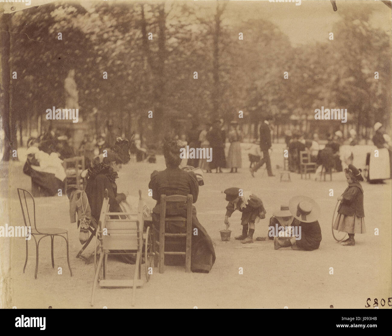 Eugène Atgets Foto „Frauen und Kinder in den Jardin du Luxembourg“ zeigt den Alltag in Paris. Das Bild spiegelt Atgets Engagement wider, die soziale Landschaft der Stadt zu dokumentieren, wobei der Fokus auf Menschen im öffentlichen Raum der Gärten liegt. Stockfoto