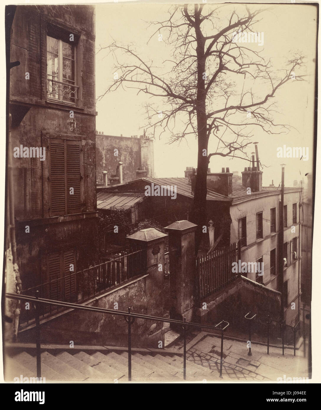 Eugène Atgets Fotografie „Treppenhaus, Montmartre“ fängt die architektonische Schönheit einer Treppe im Pariser Viertel Montmartre ein und betont das Zusammenspiel von Licht und Schatten in der städtischen Landschaft. Stockfoto