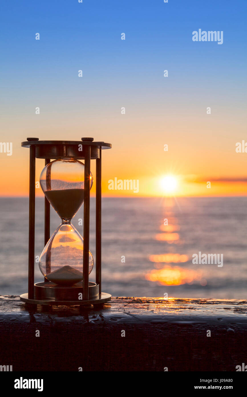 Sanduhr oder Sand Timer vor einem schönen klaren Sonnenaufgang oder Sonnenuntergang. Stockfoto