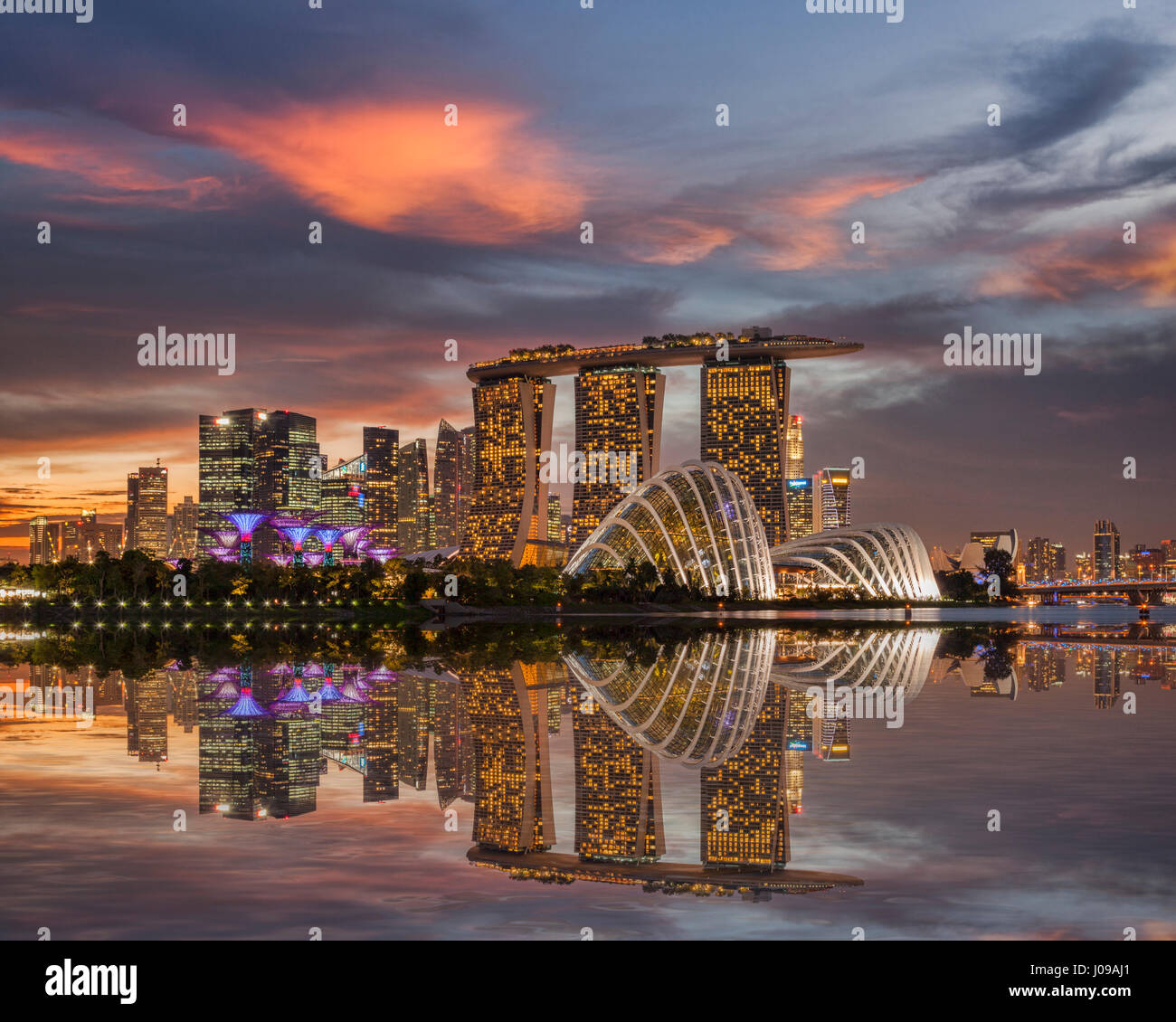 Sonnenuntergang über der Skyline von Singapur, Marina Bay Sands und die Gärten auf der Bucht reflektierenden in Marina Bay. Stockfoto