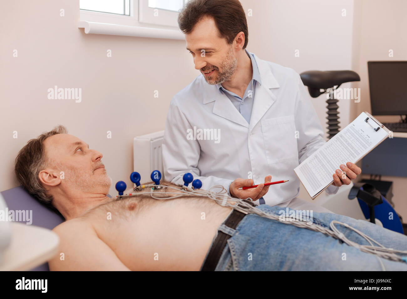 Begeistert erzählt der Patient über seine Fortschritte Kardiologe Stockfoto