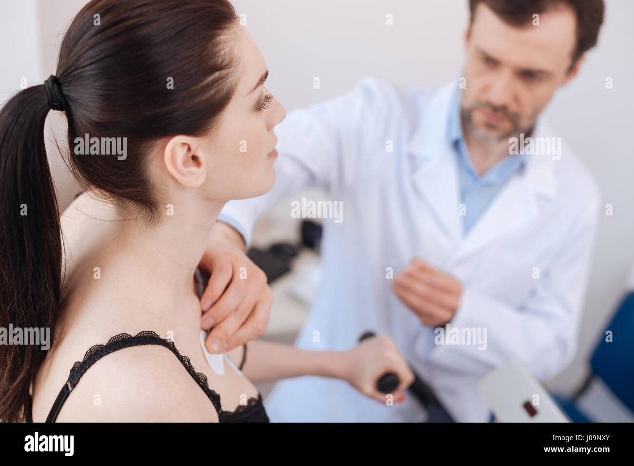 Geschickte professionelle Kardiologe mit Elektroden für Diagnostik Stockfoto