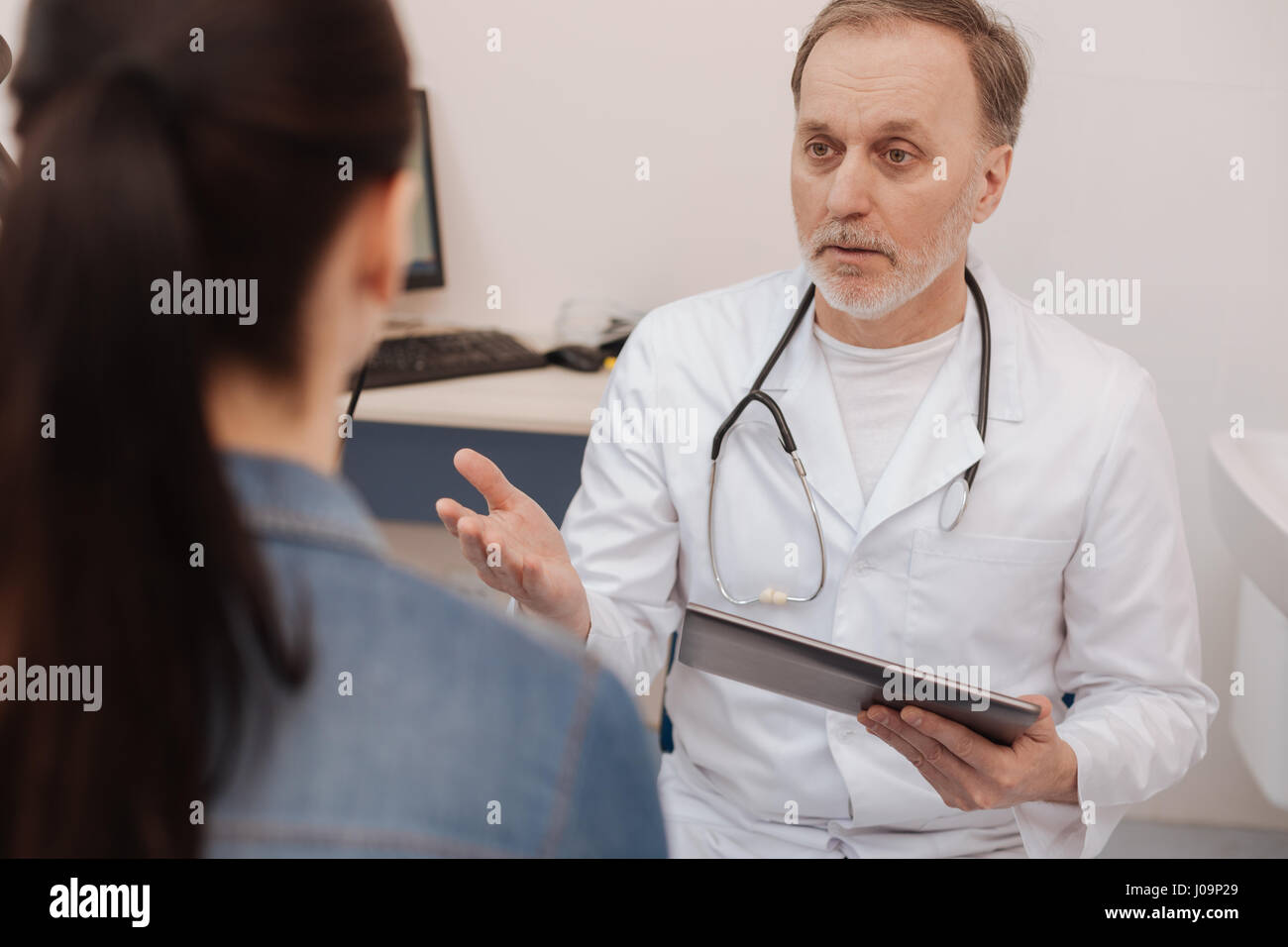 Ausgebildeten erfahrenen Arzt Behandlung seines Patienten informiert Stockfoto