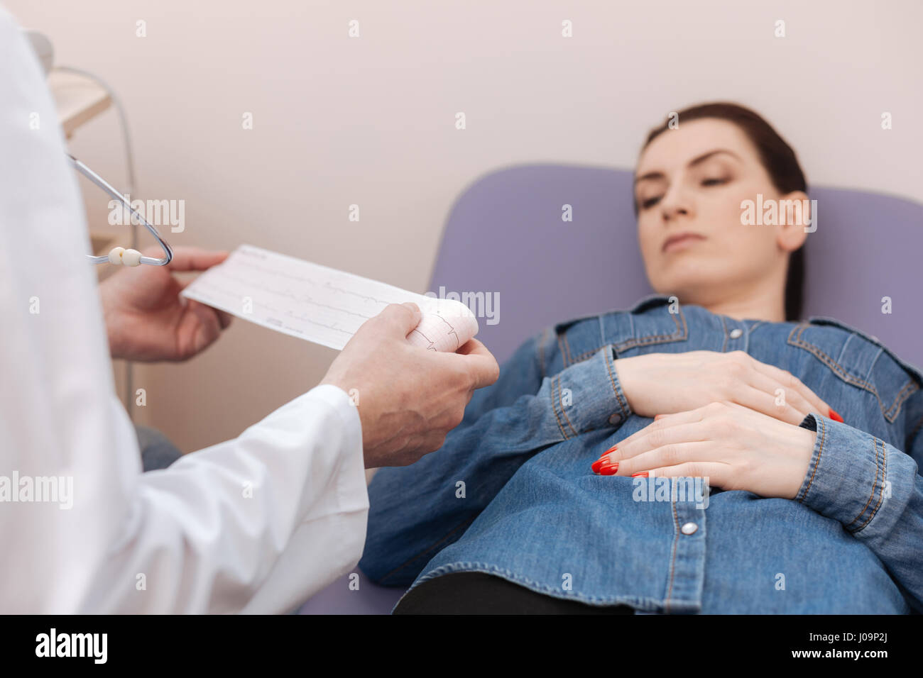 Pendelten hervorragende Spezialisten untersuchen Damen elektrokardiographischen tracings Stockfoto