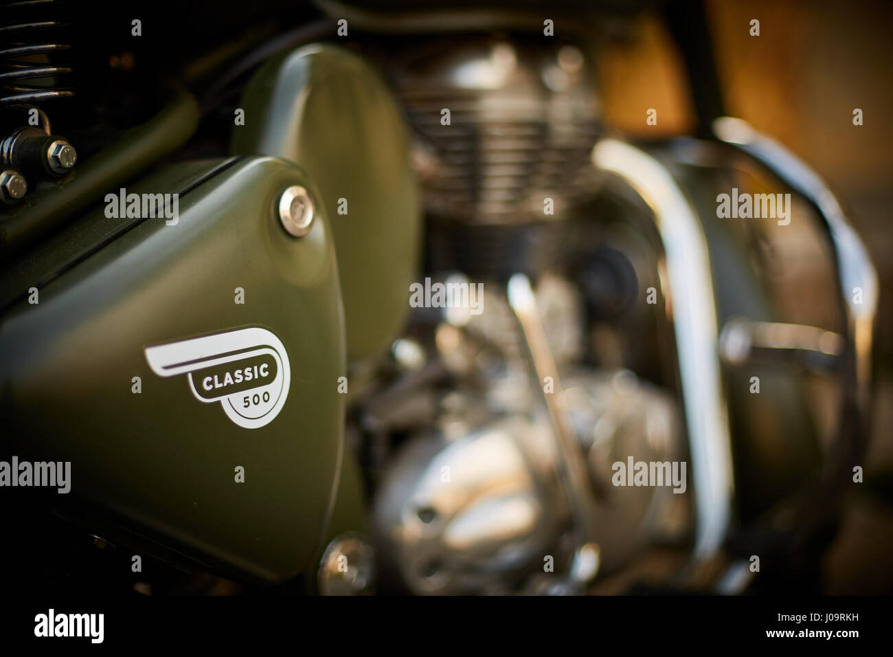 Nahaufnahme des olivgrünen Royal Enfield Classic 500 Motorrads mit Logo auf der Seitenabdeckung und Chrommotor Stockfoto