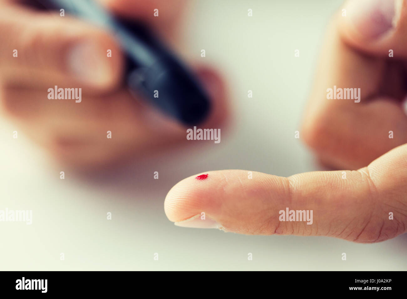 Nahaufnahme eines männlichen Finger mit Blut und Blutzuckermessgerät Stockfoto