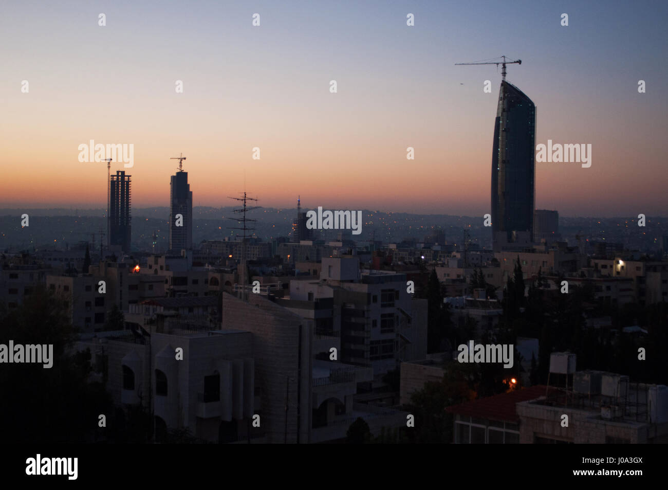 Die Skyline von Amman, die Hauptstadt und bevölkerungsreichste Stadt des Haschemitischen Königreichs Jordanien, Paläste und Häuser in der Morgendämmerung zu sehen Stockfoto