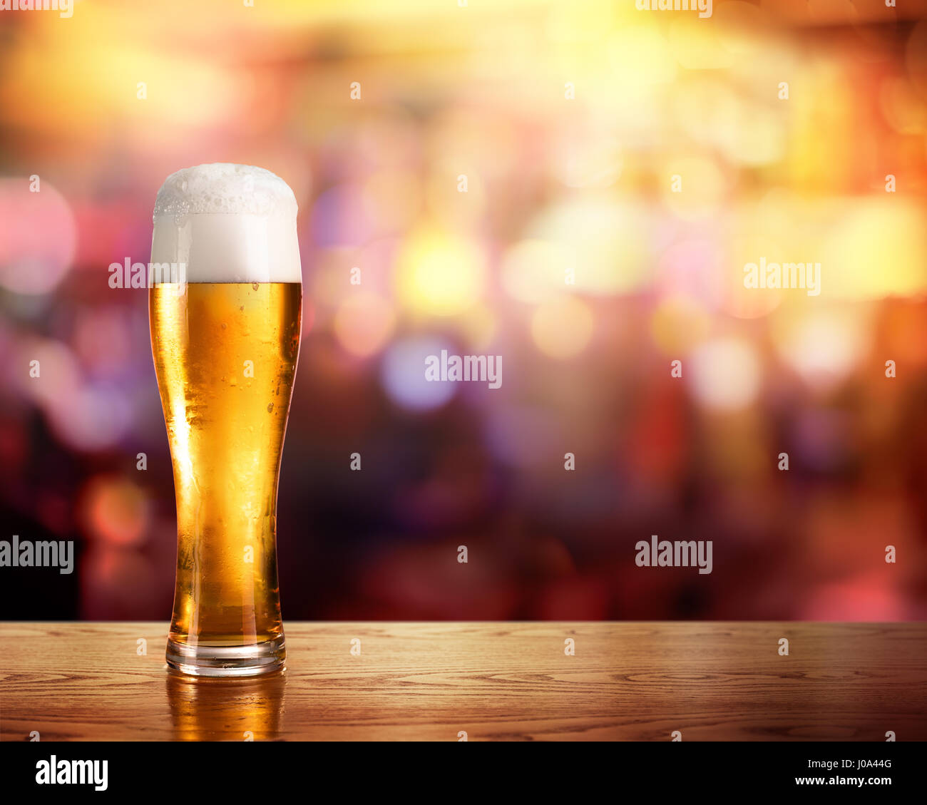 Goldene Bier im Glas mit Licht der Bar im Hintergrund Stockfoto