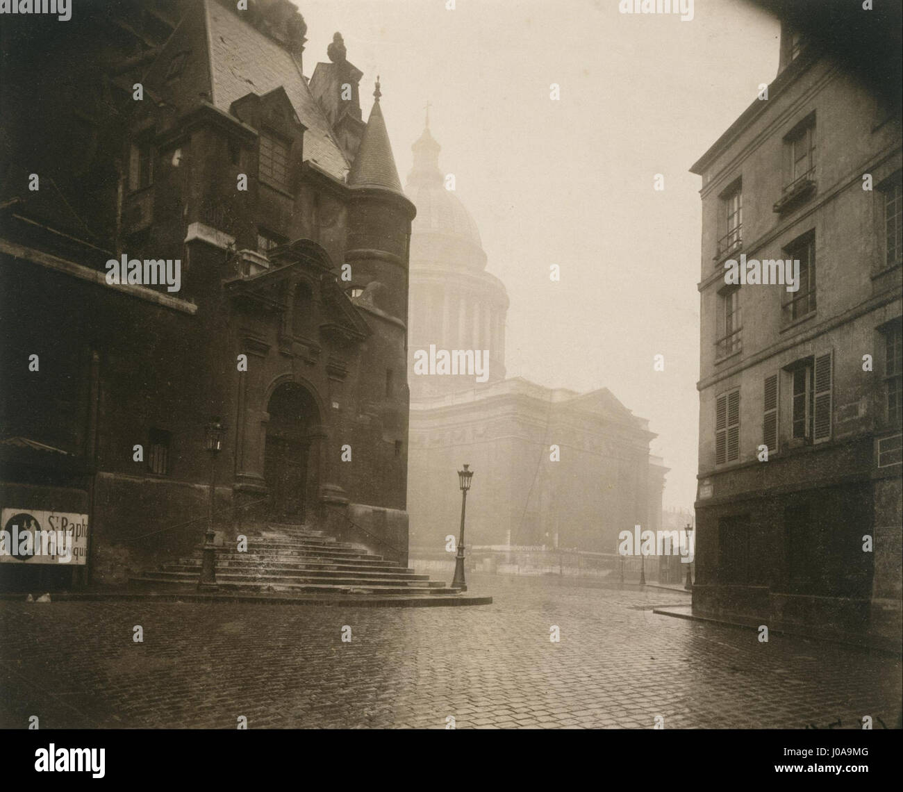 Foto von Eugène Atget 'Rue de la Montagne Ste. Genevieve' fängt die historische Pariser Straße mit ihrer unverwechselbaren Architektur und Atmosphäre ein. Atget’ Werk aus dem frühen 20. Jahrhundert dokumentiert die sich verändernde Landschaft von Paris und konzentriert sich dabei auf den Charakter seiner Straßen. Stockfoto