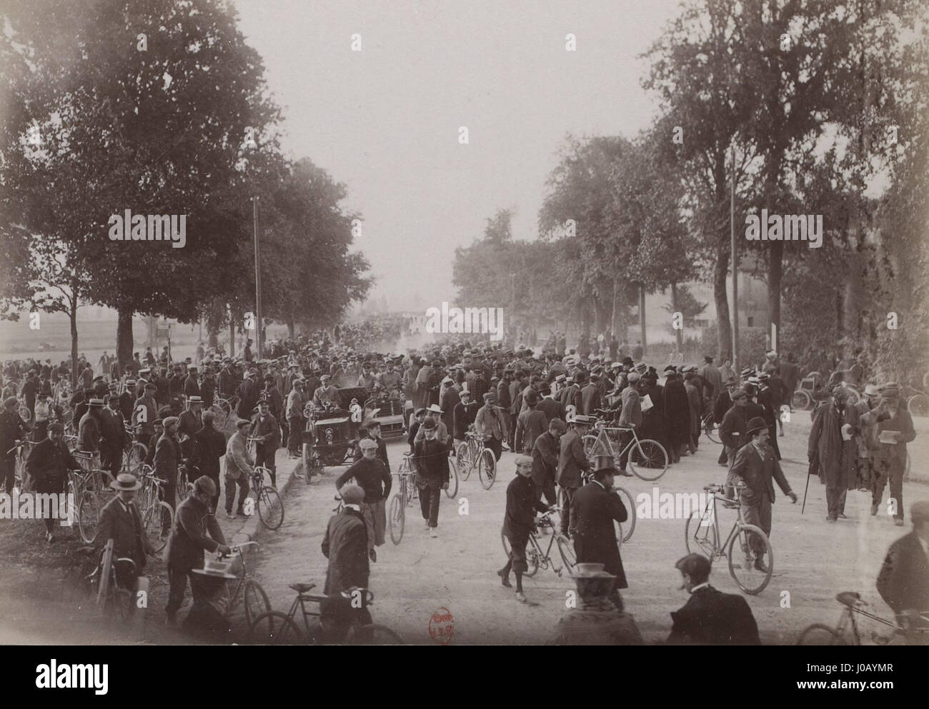 „Paris-Berlin 1901 - Départ de la Côte de Champigny“ zeigt eine Szene aus dem Rennen Paris–Berlin 1901, einem der ersten Radrennen zwischen den beiden Städten. Das Bild zeigt die Radfahrer, die ihre Reise in Champigny beginnen, und symbolisiert die Spannung und den Wettkampf des europäischen Radsports Anfang des 20. Jahrhunderts. Stockfoto