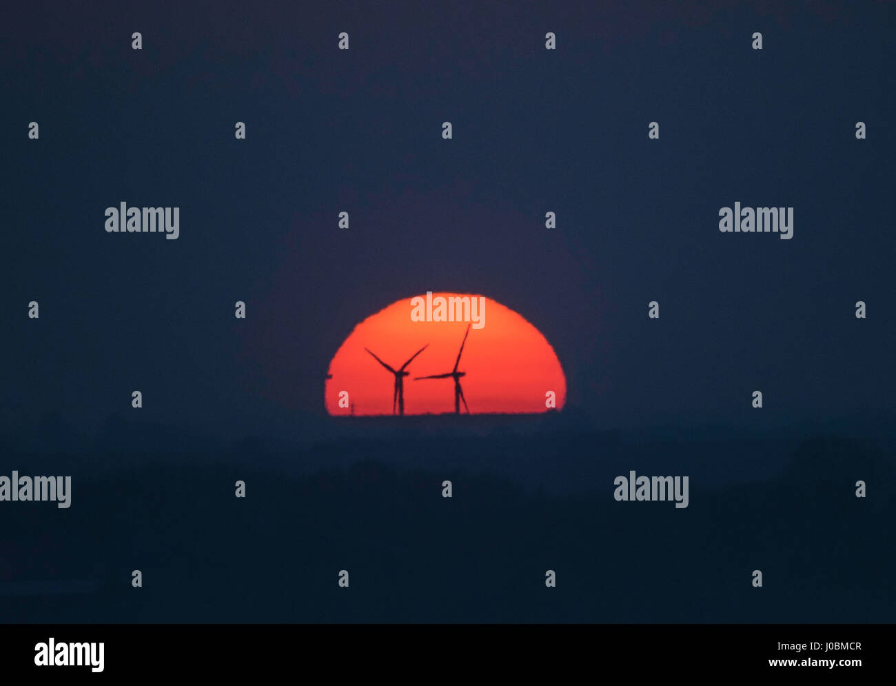 Sonnenuntergang hinter Tick Fen Windpark, in der Nähe von Warboys, Cambridgeshire, Großbritannien Stockfoto