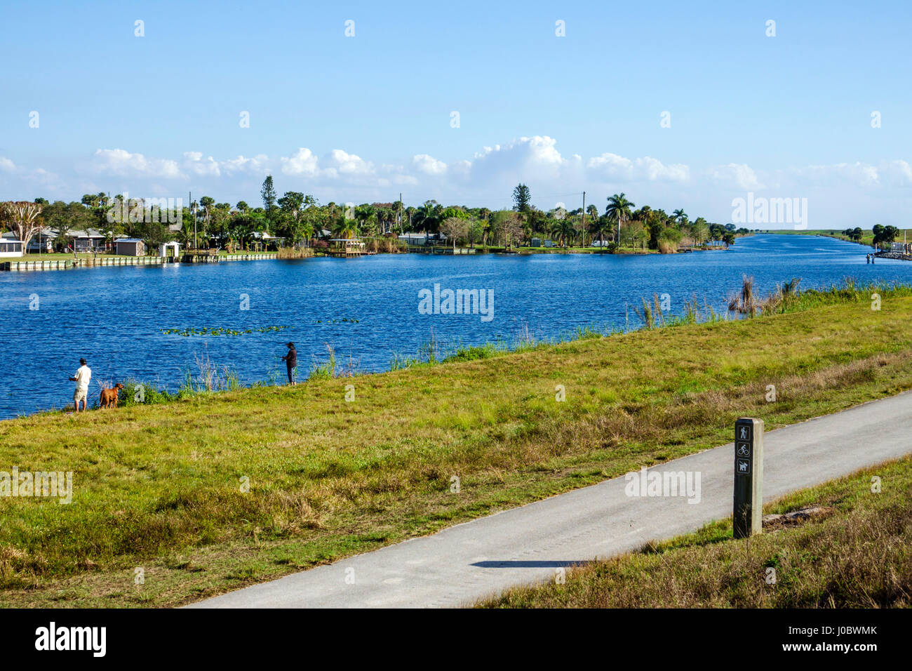 Florida Lake Okeechobee, Kanal, malerische Strecke, Park, Weg, Erwachsene Erwachsene Mann Männer männlich, Frau Frauen weibliche Dame, Hund Hunde, Angeln, am Wasser, Besucher Reisen tra Stockfoto
