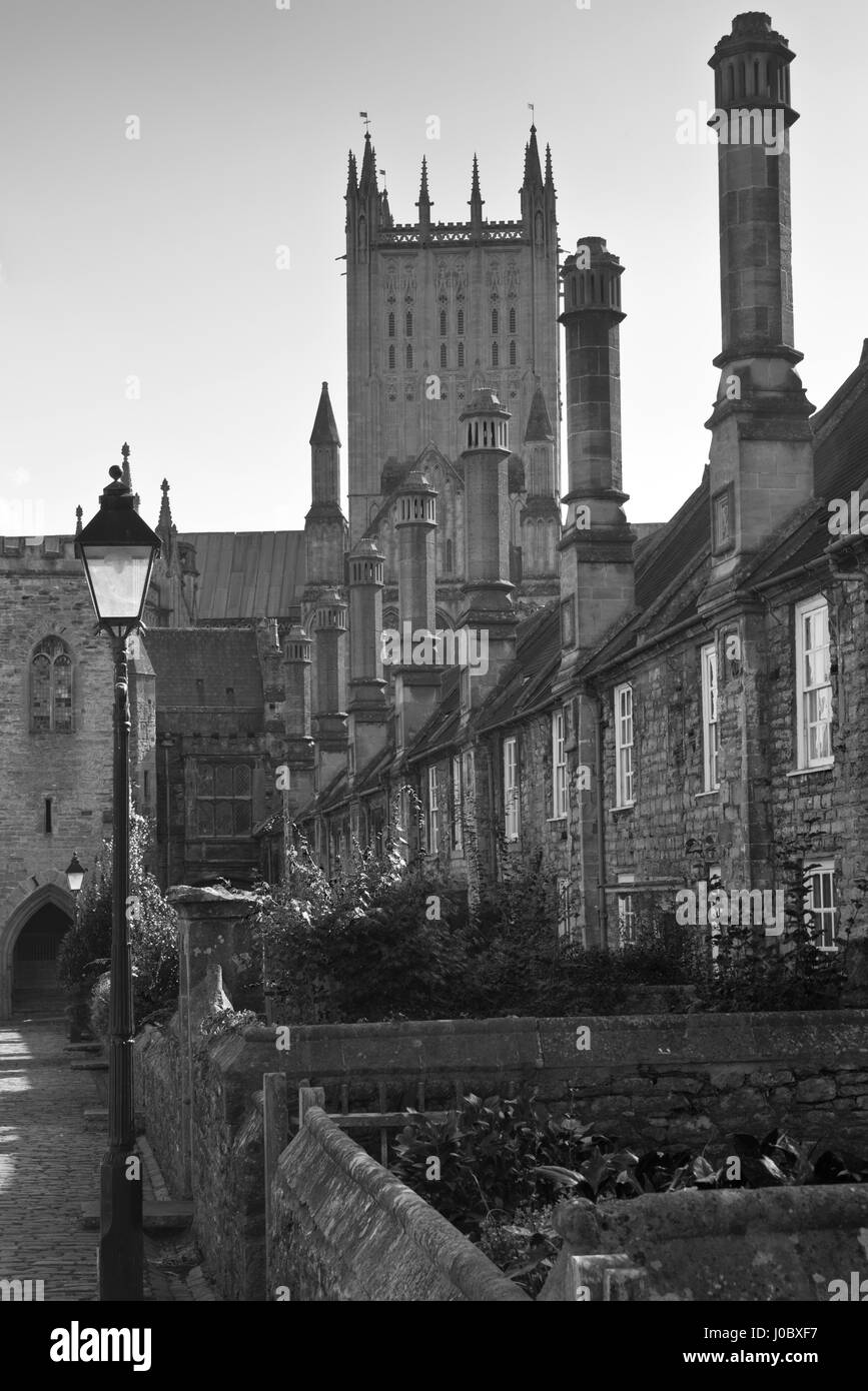 Ein b&w Bild der enge Vikare, einer mittelalterlichen Straße mit Turm von Wells Kathedrale im Hintergrund. Brunnen befindet sich in Somerset, England, UK Stockfoto