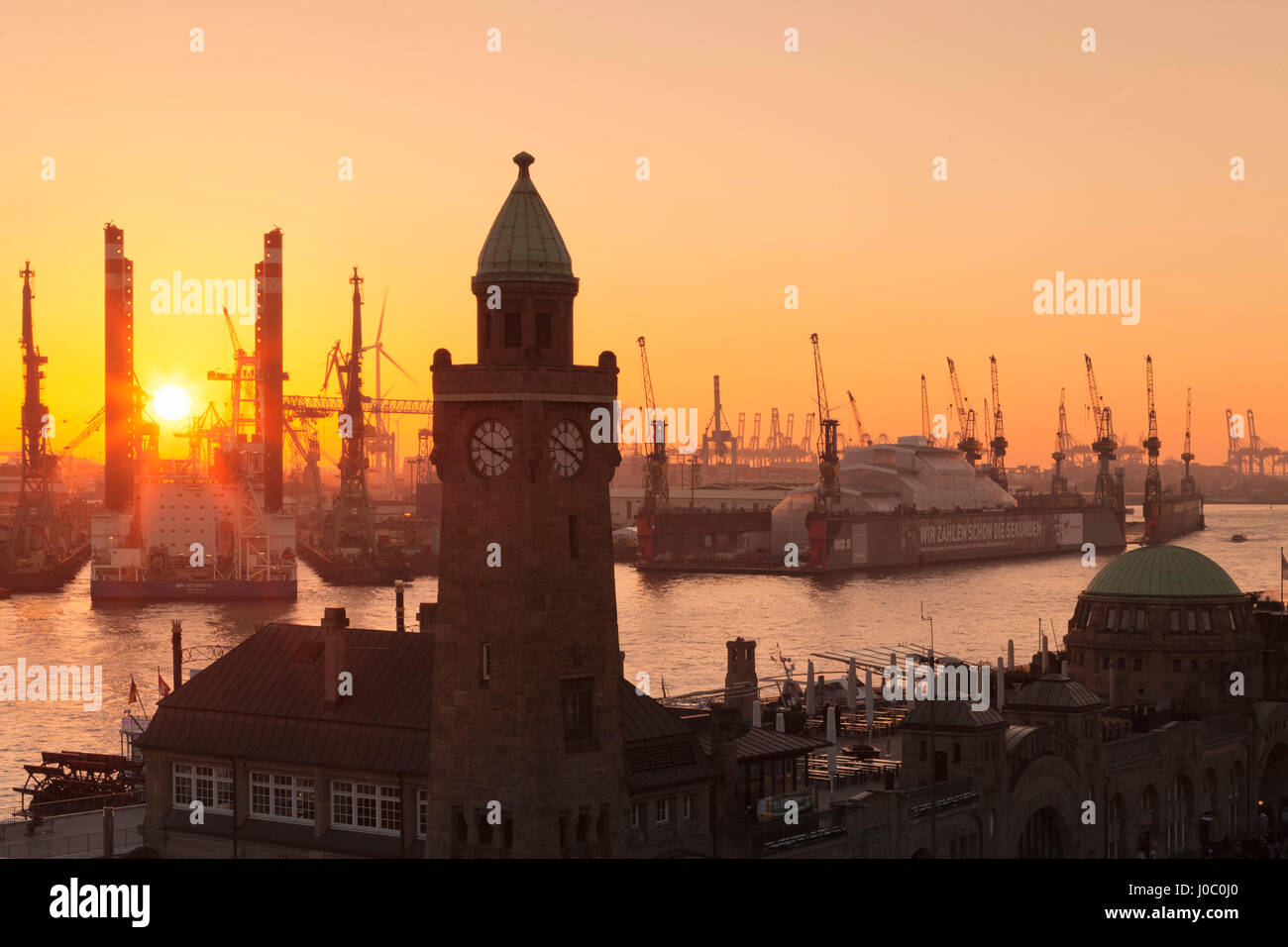 St. Pauli Landungsbruecken Pier gegen Hafen bei Sonnenuntergang, Hamburg, Hansestadt, Deutschland Stockfoto