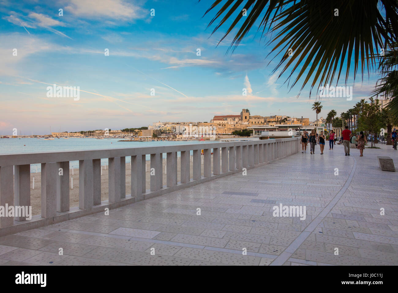 Touristen auf der Promenade mit der mittelalterlichen Altstadt im Hintergrund, Otranto, Provinz Lecce, Apulien, Italien Stockfoto
