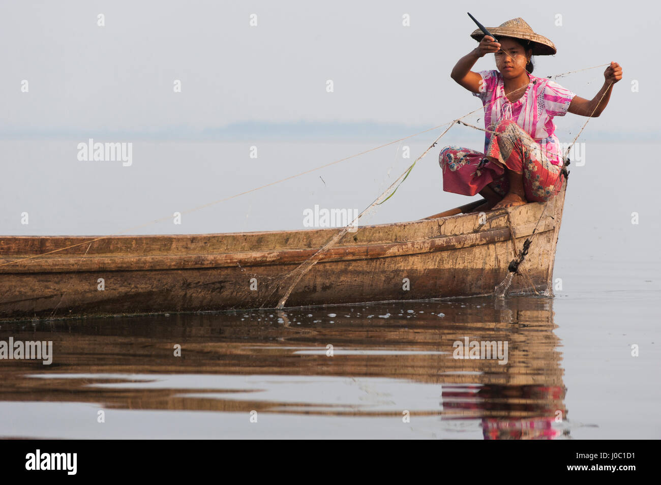 Eine junge Frau zieht in ihre Netze am Ende des Tages am Indawgyi Lake, Kachin-Staat, Myanmar (Burma), Asien Stockfoto