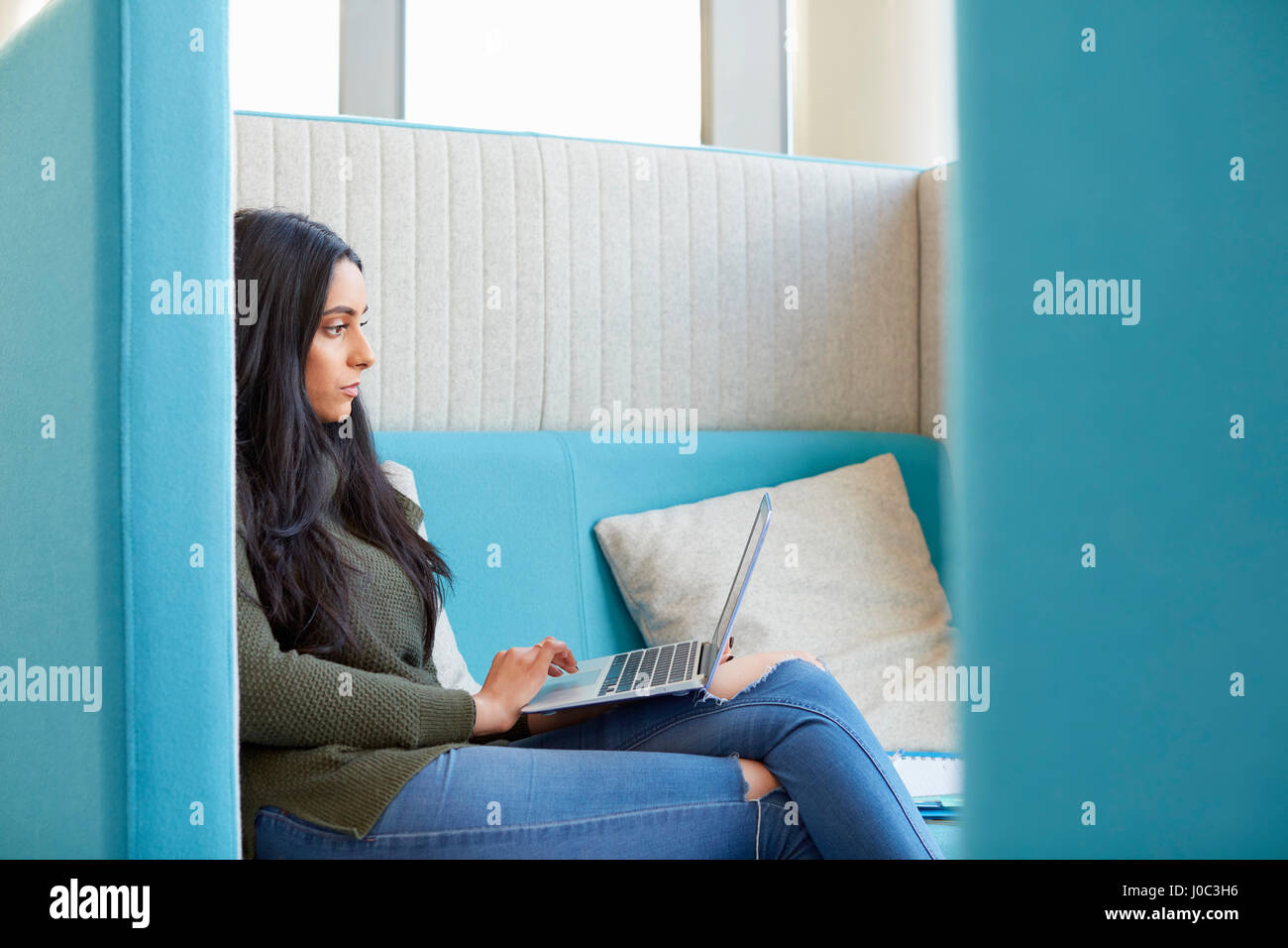 Studentin mit Laptop in modernen Kabine Stockfoto