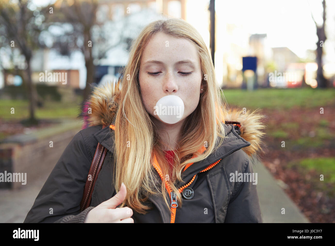 Porträt der jungen Frau, im Freien, Seifenblase mit bubblegum Stockfoto