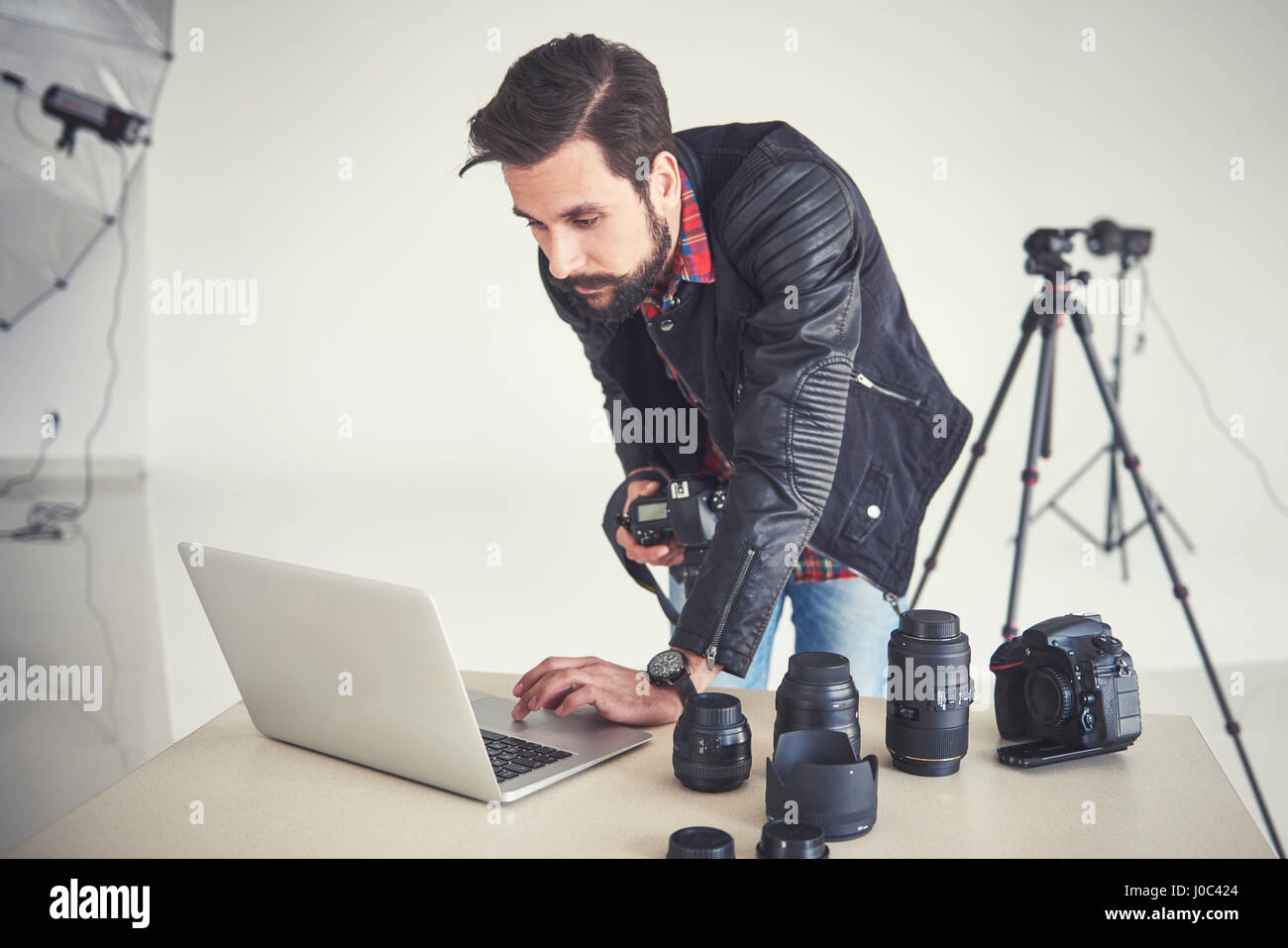 Männlichen Fotografen Überprüfung Studio Fotoshooting auf laptop Stockfoto