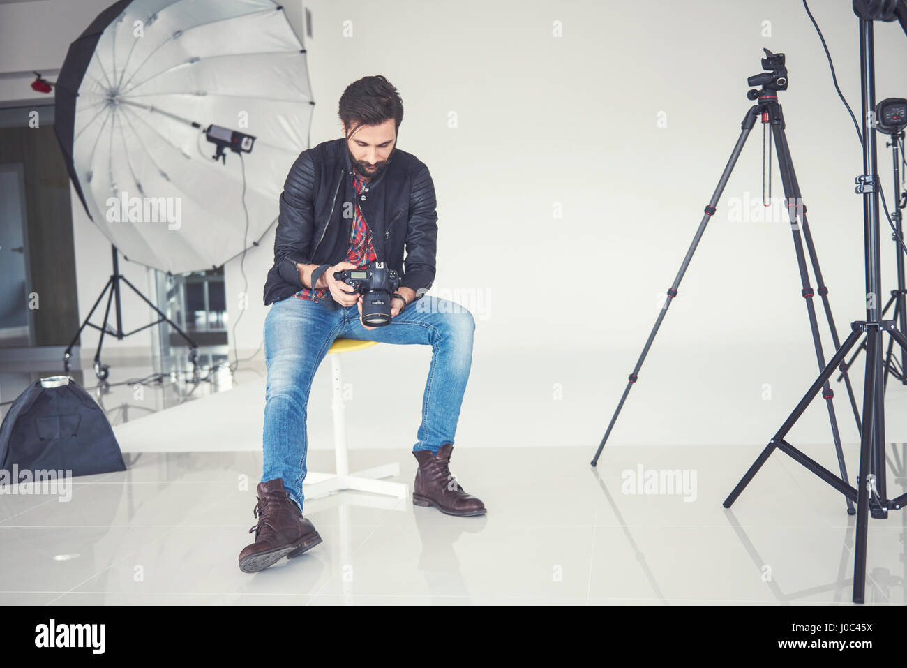 Männlichen Fotografen Überprüfung Studio Fotoshooting auf digitale slr Stockfoto