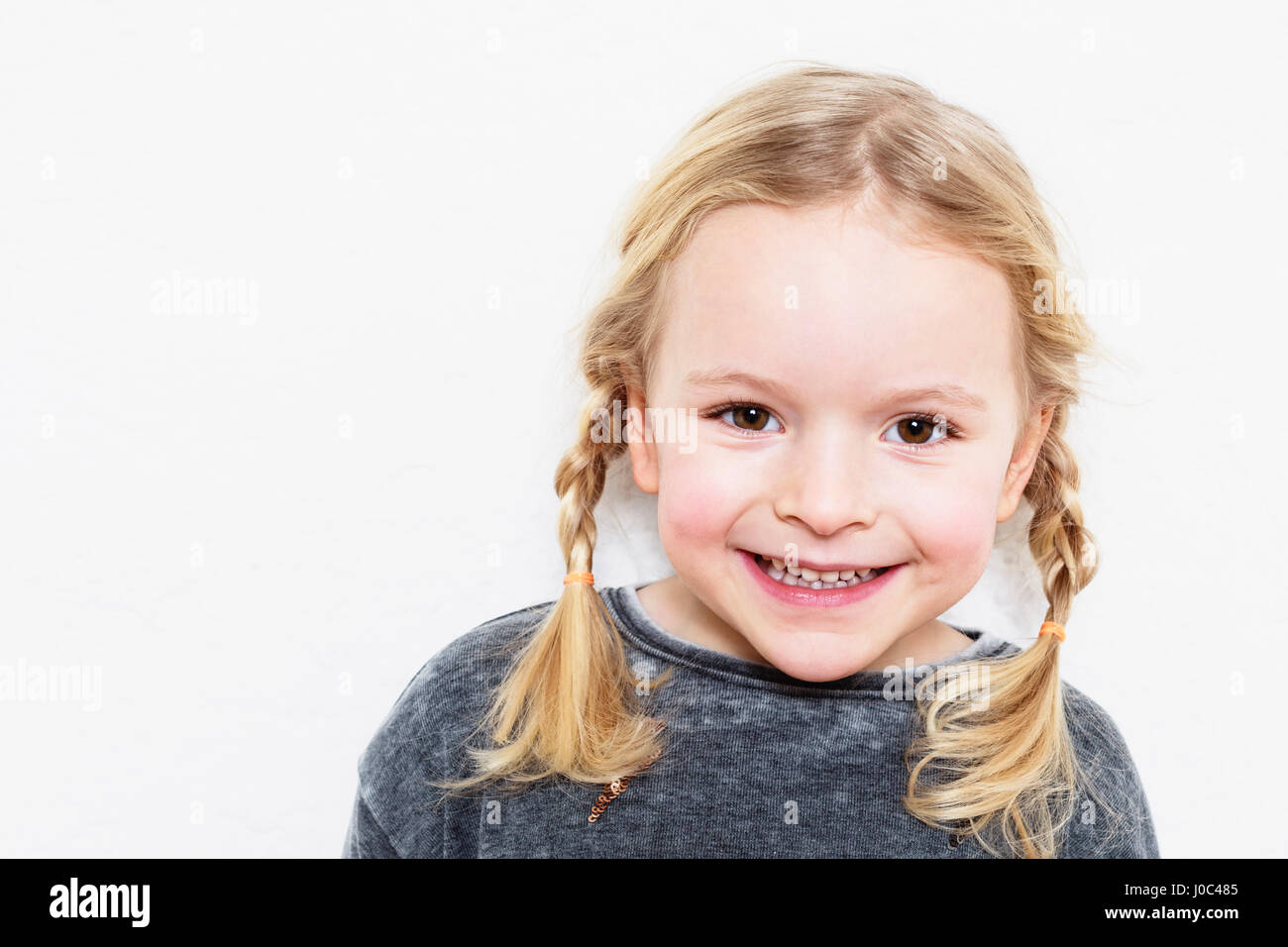 Porträt des jungen Mädchens, lächelnd, vor weißem Hintergrund Stockfoto