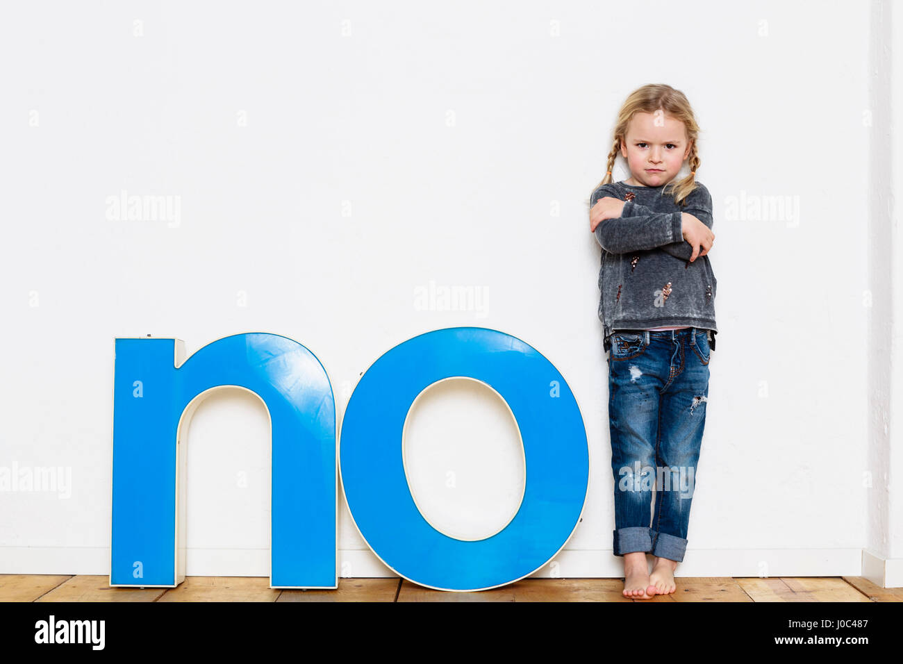 Junge Mädchen stehen neben großen dreidimensionalen Buchstaben, das Wort Nein Stockfoto