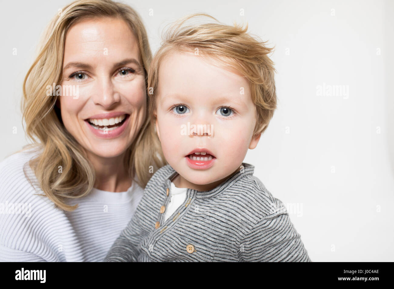 Porträt von Mutter und Sohn vor weißem Hintergrund, Lächeln Stockfoto