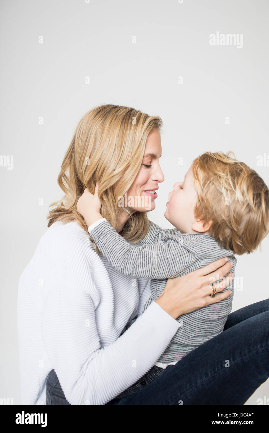 Porträt von Mutter und Sohn vor weißem Hintergrund, Gesicht, Lächeln Stockfoto