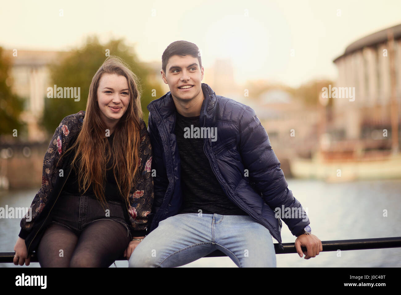 Porträt von zwei Freunden, sitzen auf Geländer Fluss, Bristol, UK Stockfoto