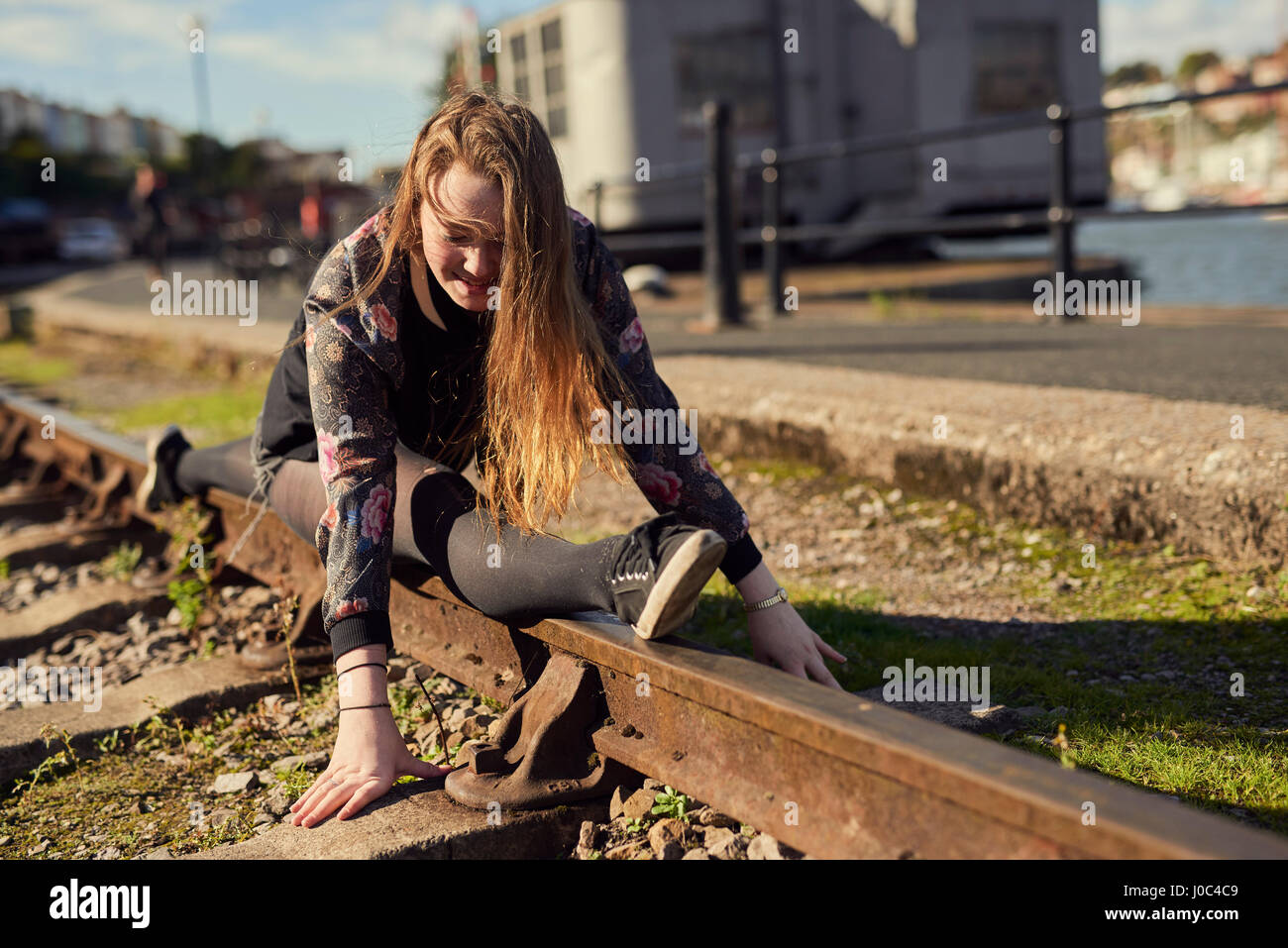 Junge Frau dabei spaltet, balancieren auf Bahnstrecke, Bristol, UK Stockfoto