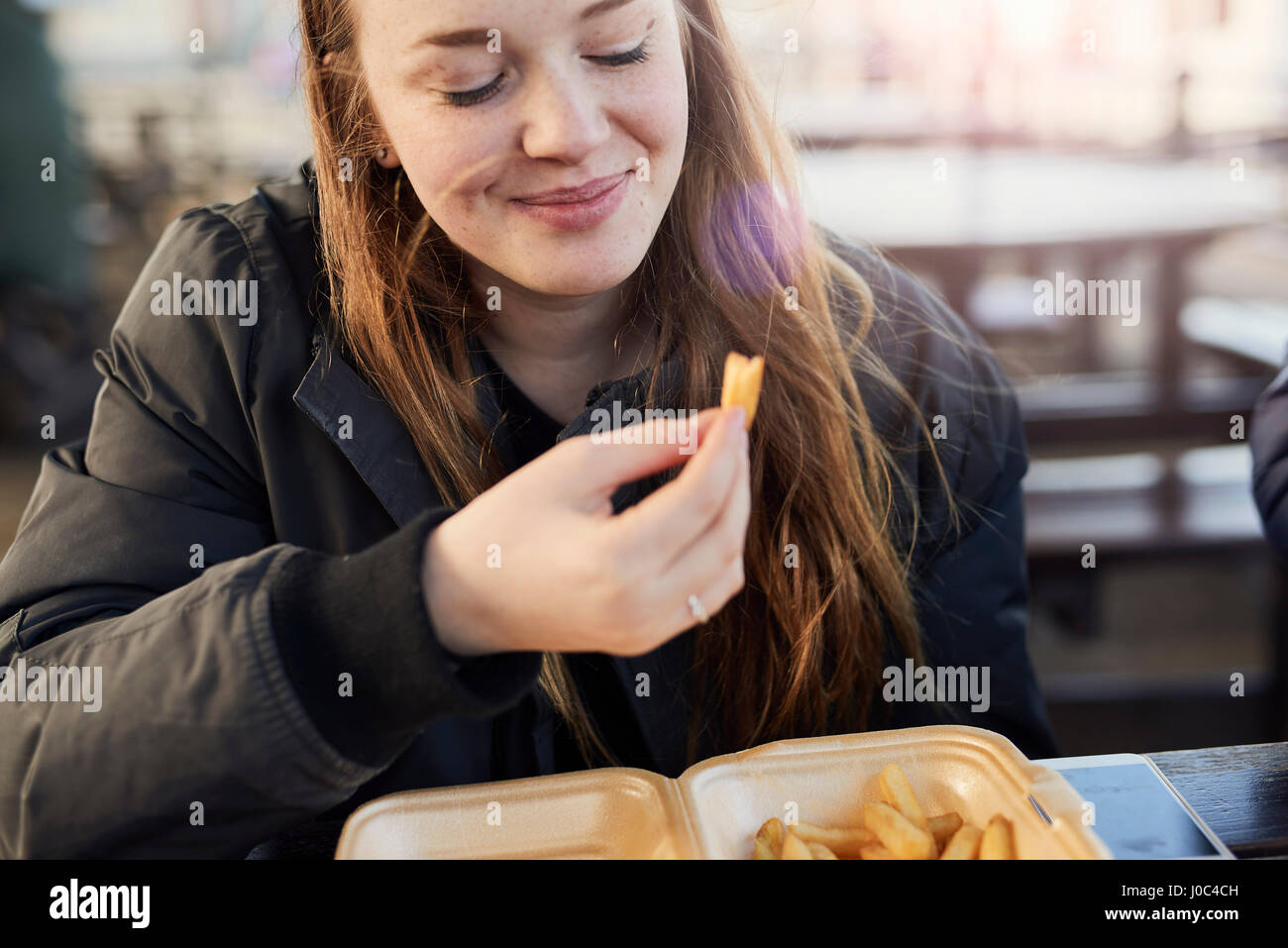 Porträt der jungen Frau, im Freien, Essen Chips, Bristol, UK Stockfoto