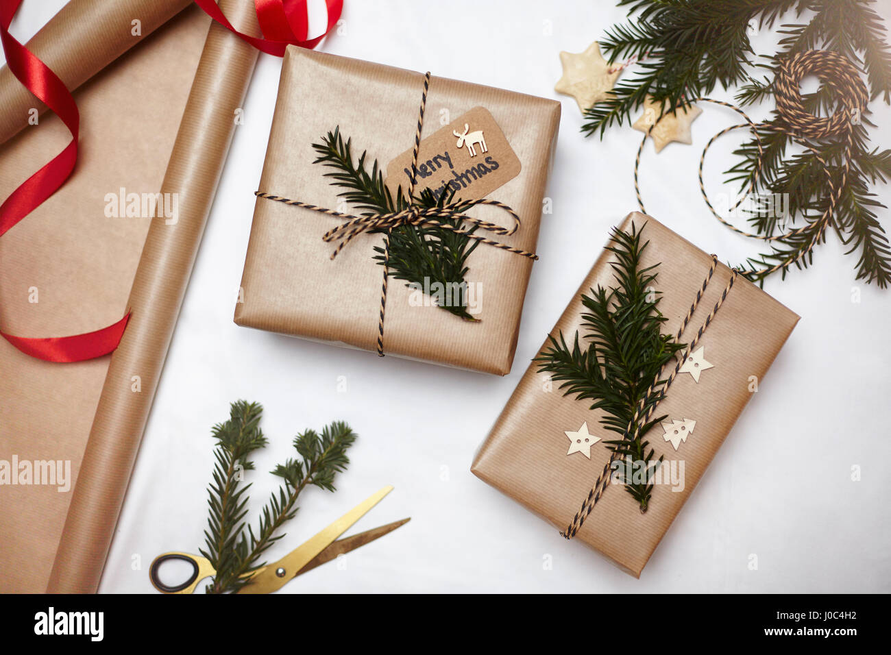 Weihnachtsgeschenke verpackt in braunem Papier, dekoriert mit Farn und String, Draufsicht Stockfoto