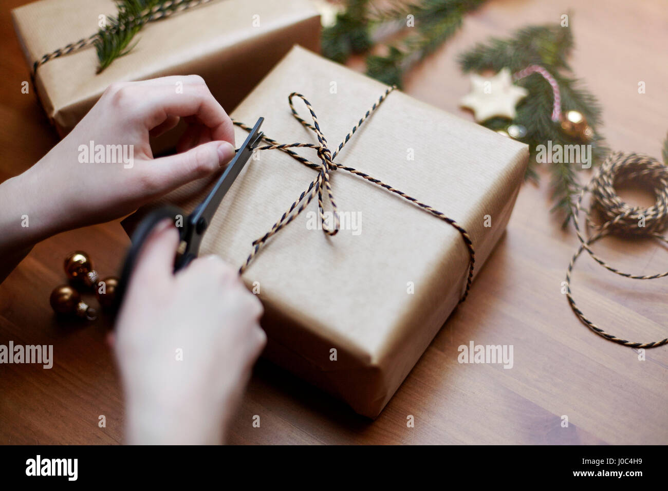 Frau binden Bogen auf Weihnachtsgeschenk mit Schnur, Nahaufnahme Stockfoto