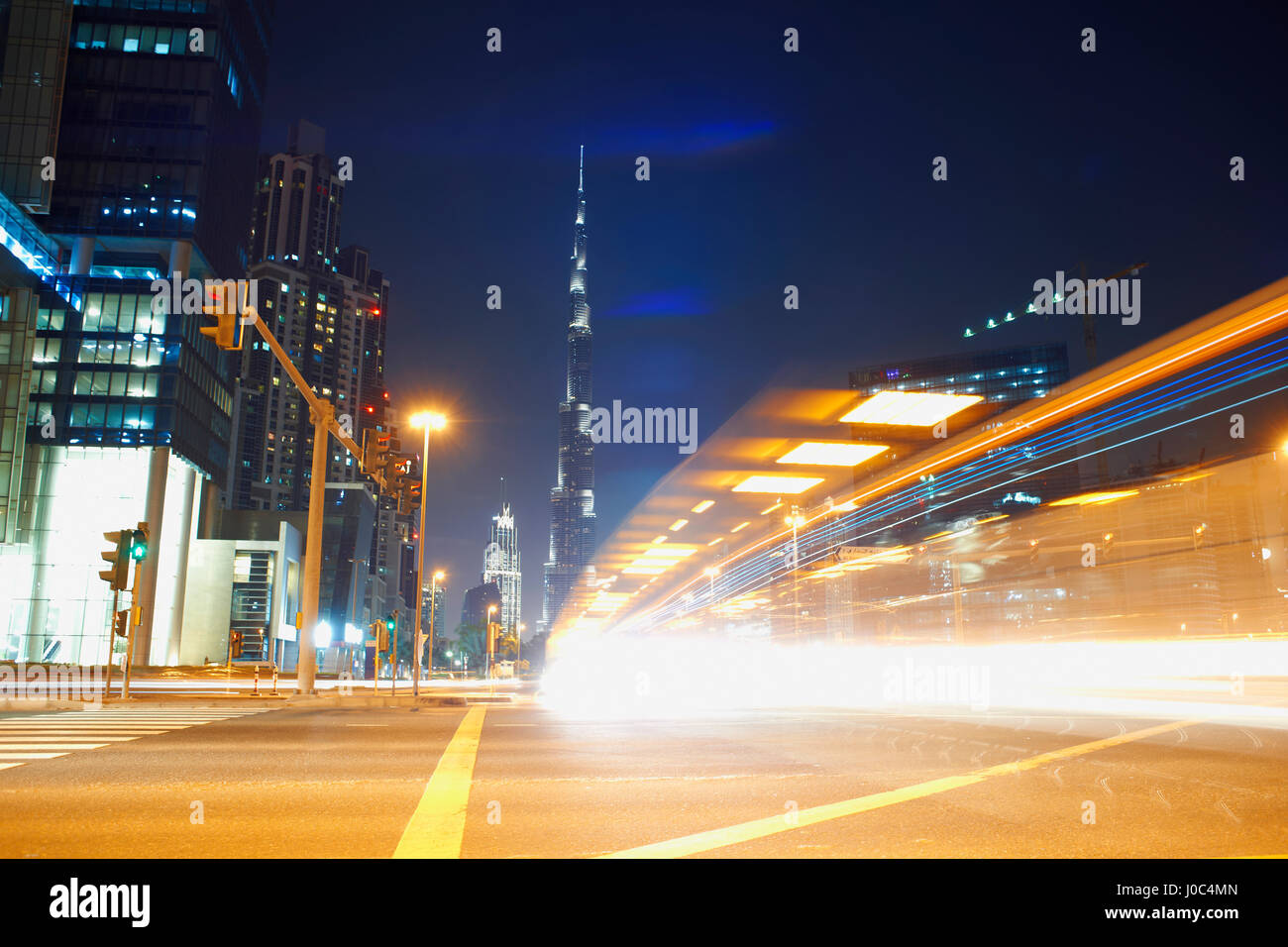 Stadtbild bei Nacht zeigt Burj Khalifa im Hintergrund und Lichtspuren, Dubai, Vereinigte Arabische Emirate Stockfoto