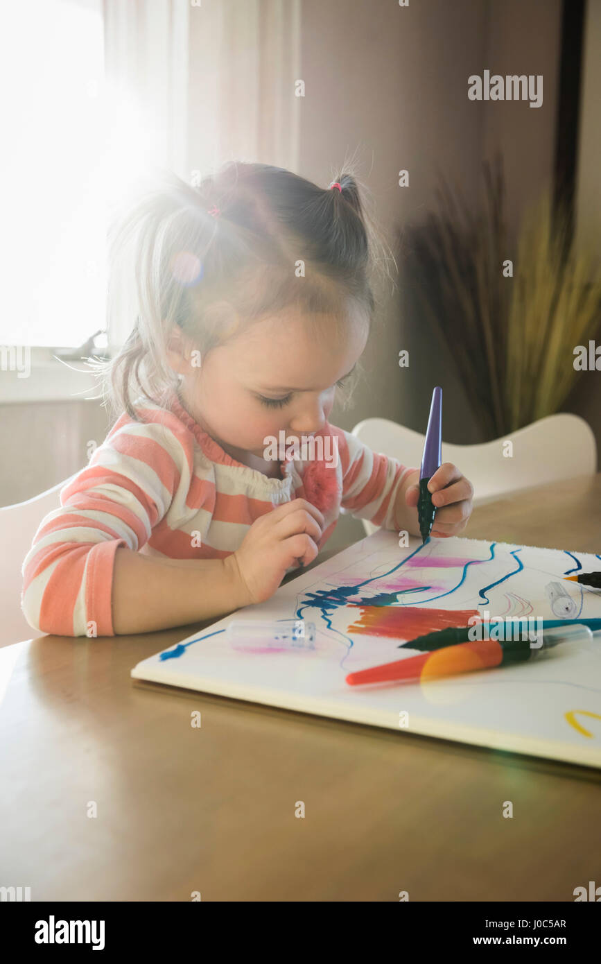 Weiblichen Kleinkind am Tisch zeichnen im Skizzenbuch Stockfoto