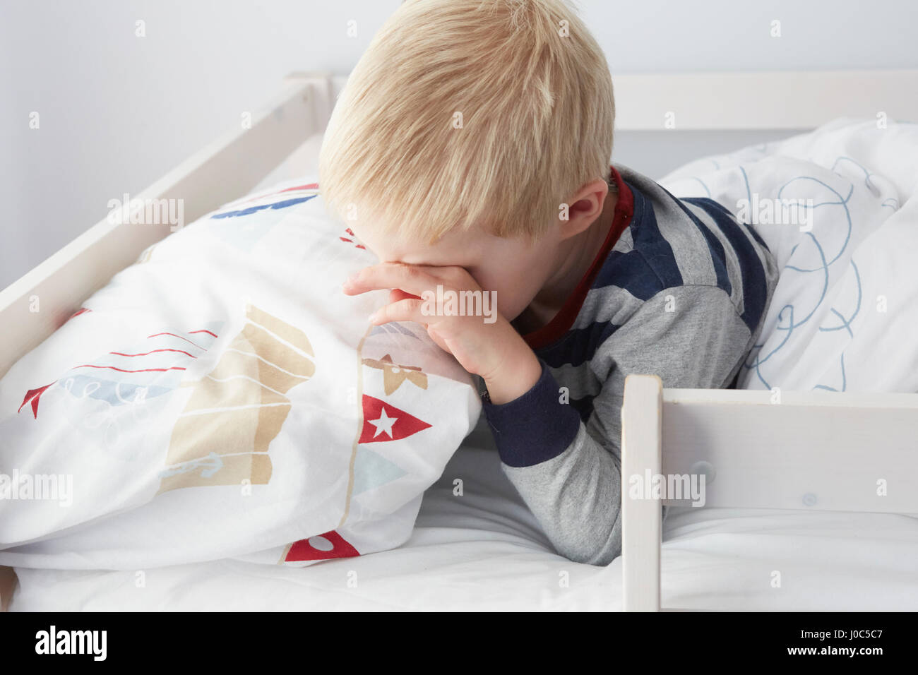 Junge im Bett aufwachen Stockfoto