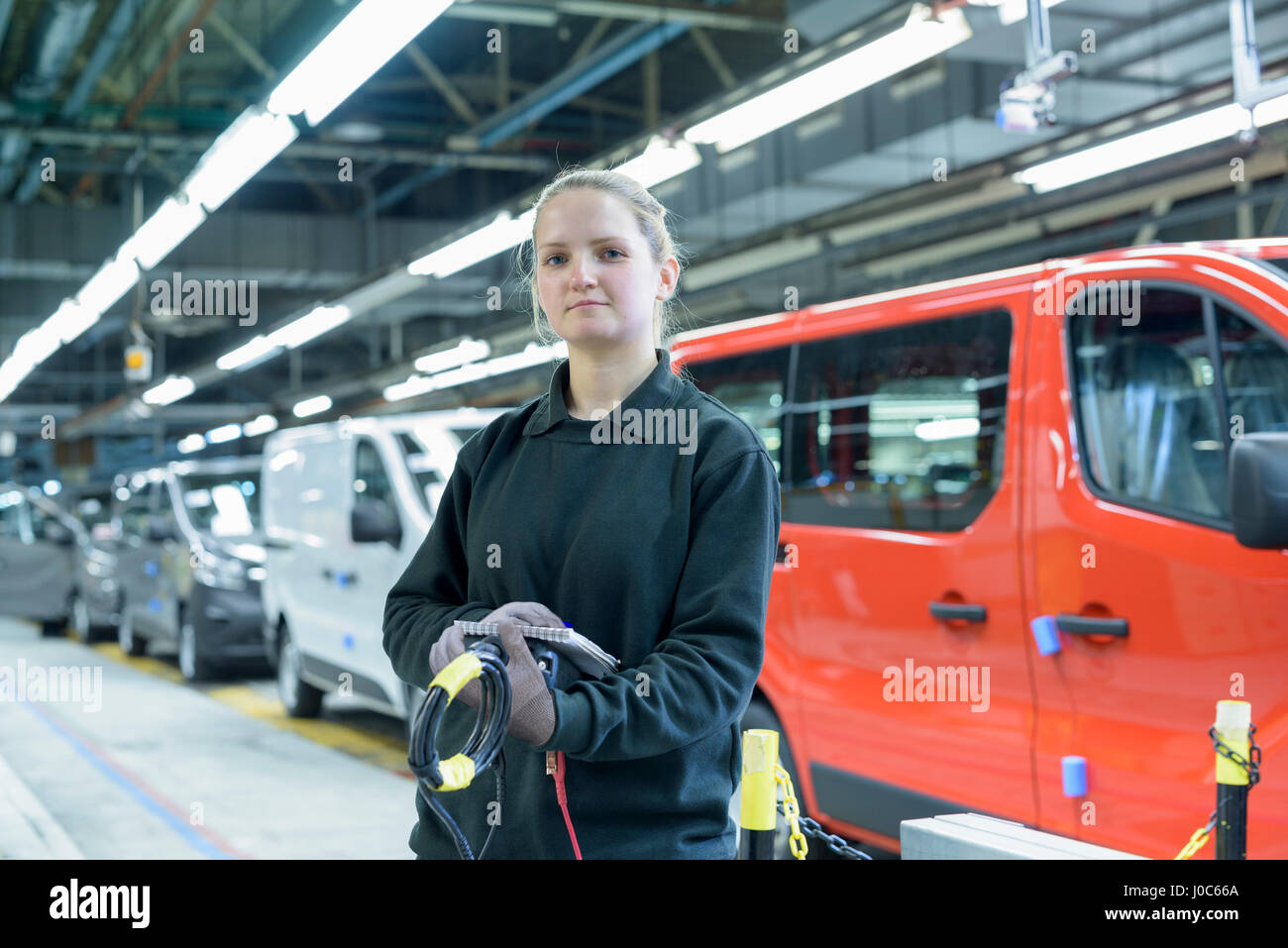 Weiblichen Lehrling Ingenieur auf der Produktionslinie in Autofabrik, Porträt Stockfoto