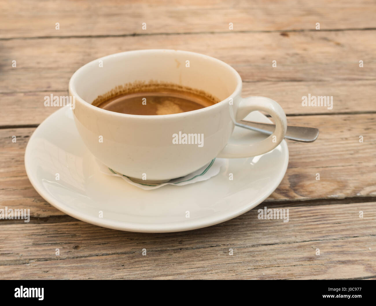 Weiße Tasse mit einem doppelten Espresso auf einem Holztisch Stockfoto