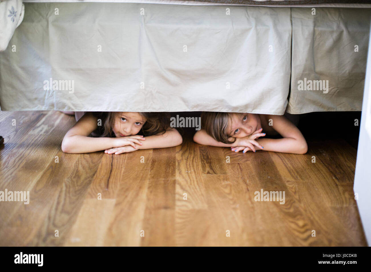 Jungen und Mädchen versteckt unter Bett Stockfoto