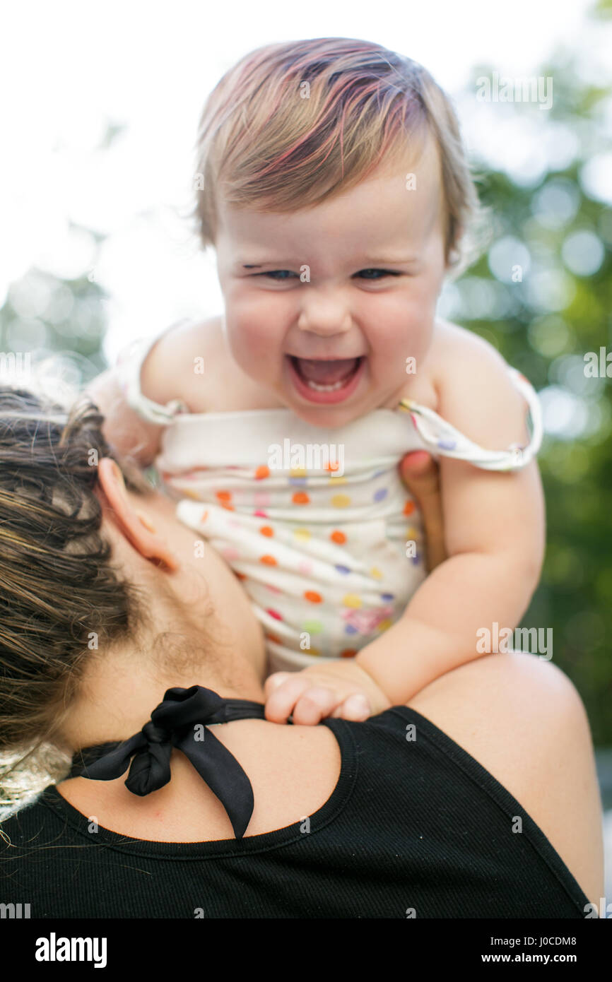 Über Schulter Blick auf Frau mit Kleinkind Tochter im Garten Stockfoto