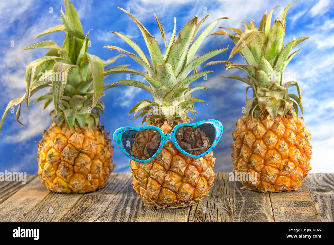 Ananas mit Herz geformt Sonnenbrille auf rustikalen Holz Stockfoto