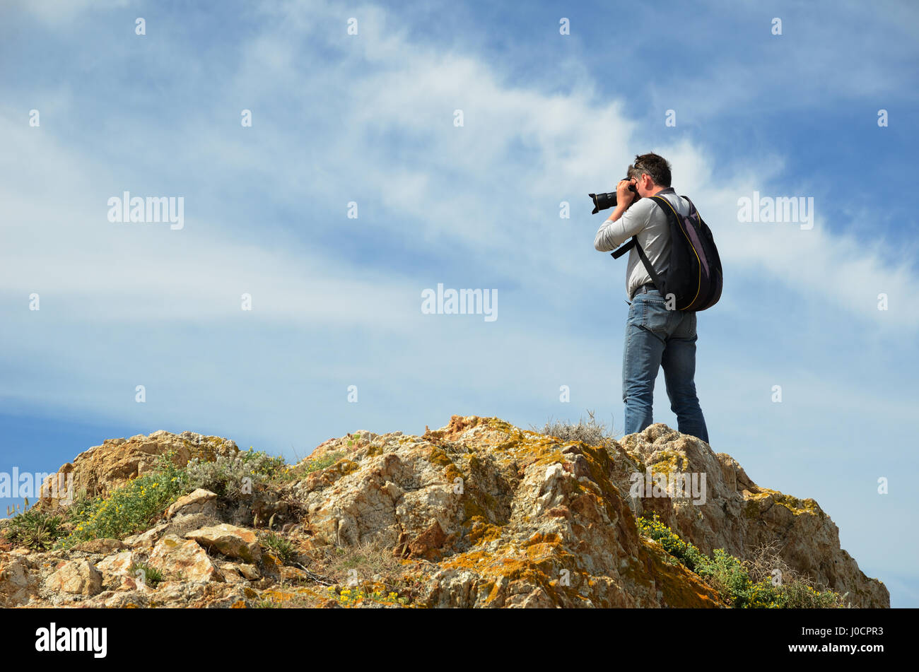 Der Tourist ist in der Nähe der Stadt l ' Ile Rousse in der korsischen Küste auf der Oberseite der roten Felseninsel Ile De La Pietra fotografieren. Stockfoto