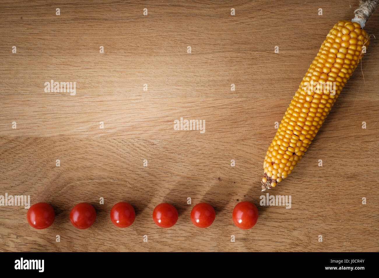 Holztisch mit Tomaten und Maiskolben mit Textfreiraum Stockfoto