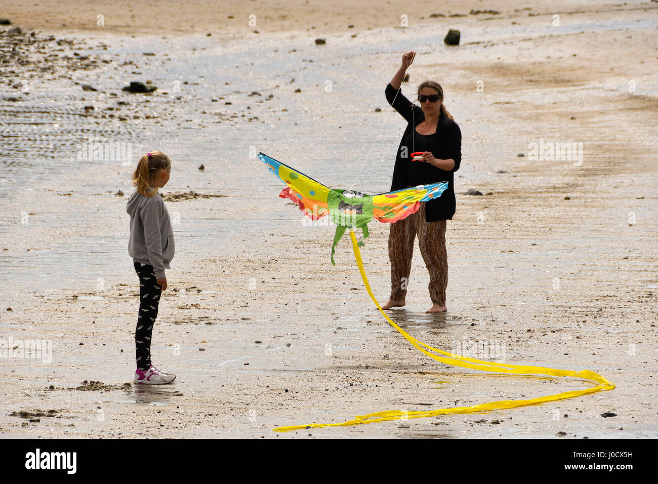 Lyme Regis, Dorset, UK. 11. April 2017. Großbritannien Wetter. Eine Mutter und Tochter startet einen Drachen an einem sonnigen aber kalten Tag im Lyme Regis in Dorset. Bildnachweis: Graham Hunt/Alamy Live-Nachrichten Stockfoto