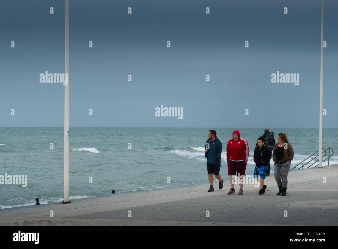 Aberystwyth Wales UK.  Mittwoch, 12. April 2017 UK Wetter: kalter, grau, windiger und bewölkter Tag in Aberystwyth, Wales, wie Familien Fuß entlang der Strandpromenade im Vorfeld bis Ostern Urlaubswochenende Foto Keith Morris / Alamy Live News Stockfoto