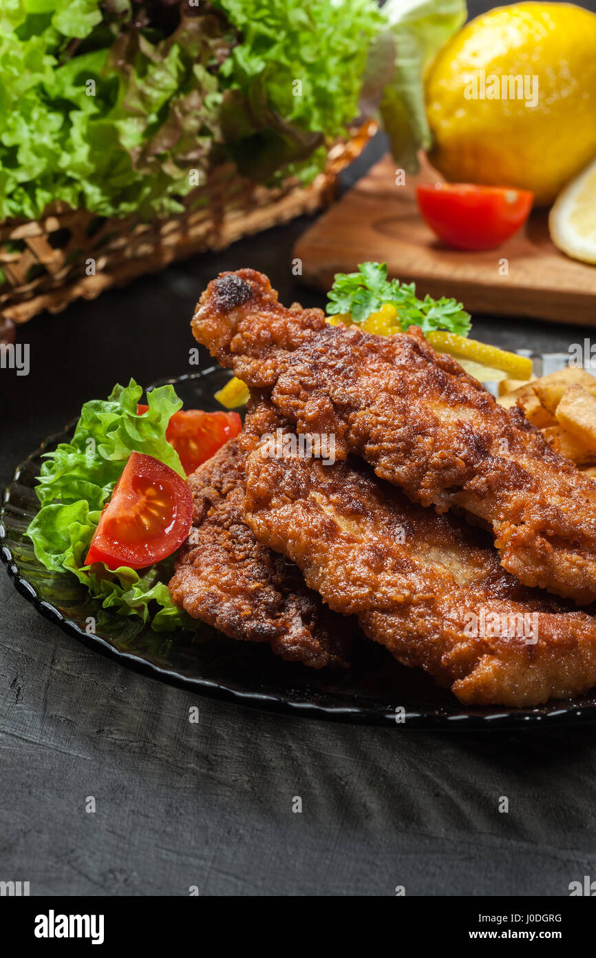 Gebratener Fisch in knuspriger Teig mit Chips auf einem Teller Stockfoto