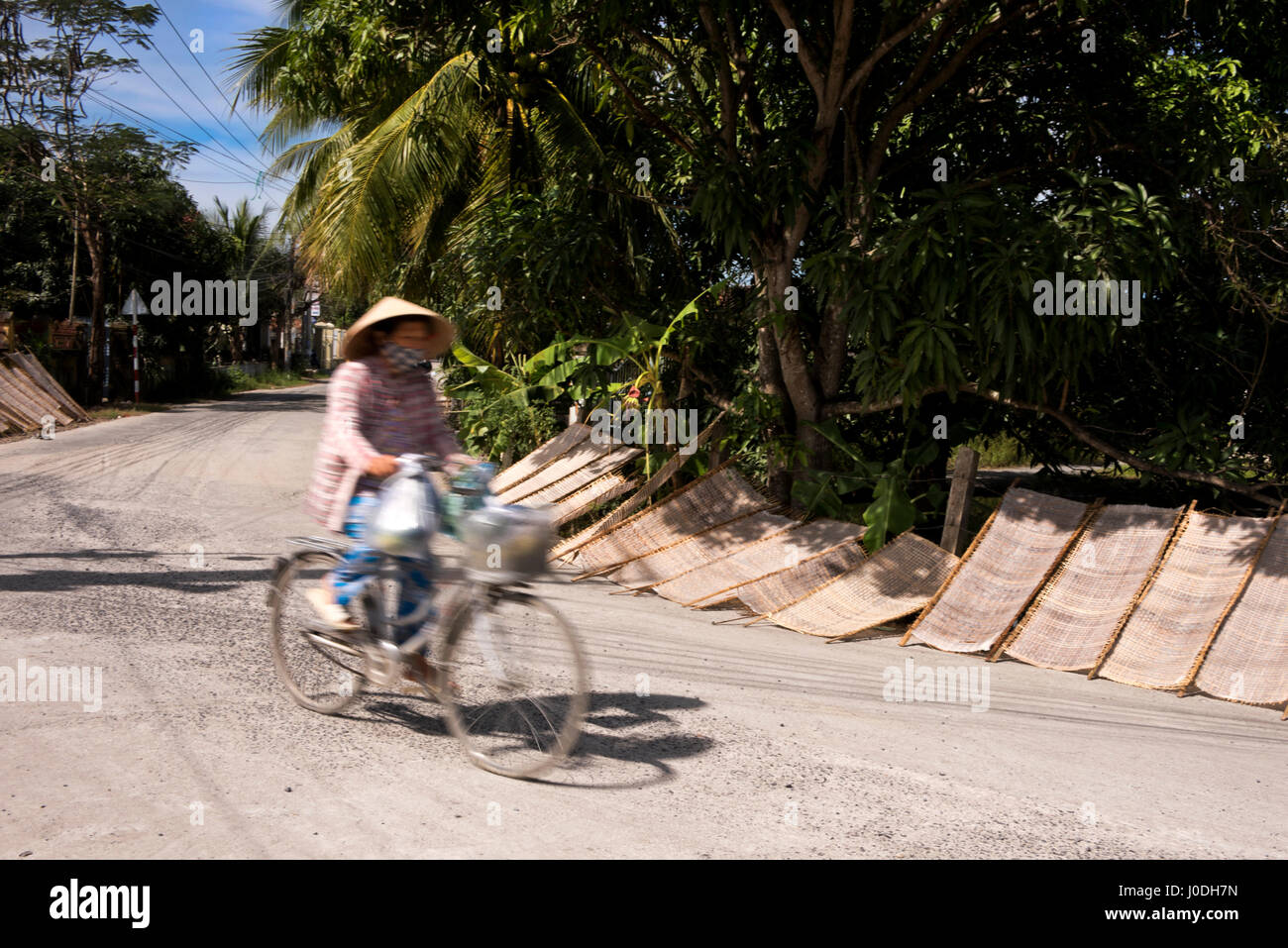 Horizontale Straßenansicht der traditionellen Reis Papier trocknen in der Sonne am Straßenrand in Vietnam. Stockfoto